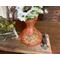 A handmade gourd vase featuring a cat stretching. I drew a paisley design inside the cat. The artwork is wood burned onto the gourd shell. 